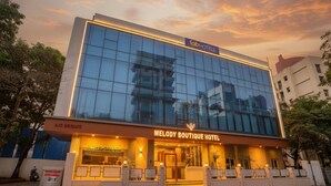 A modern hotel with a glass facade, a prominent entrance, and a sign for 'Melody Boutique Hotel'. - Fabhotel Melody Boutique (Thane)