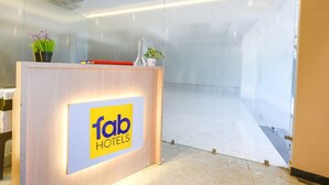 A reception desk with a 'fab hotels' sign, potted plants, and a modern interior design. - FabHotel Arjun Luxury Banquets and Rooms (New Delhi)