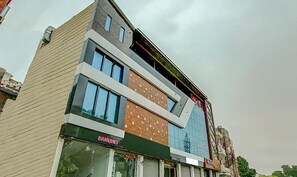 A multi-story building with a modern architectural design, featuring a mix of glass and wood paneling on the facade. - Fabhotel Aditya And Kings (Panchkula)