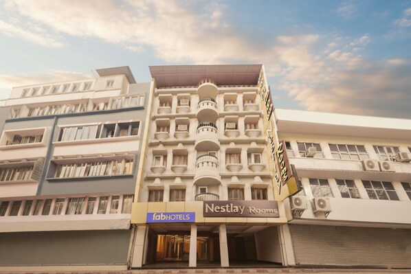 A multi-story hotel with a prominent 'Nestlay Rooms' sign. - Fabhotel Nestlay Rooms High Court (Chennai)