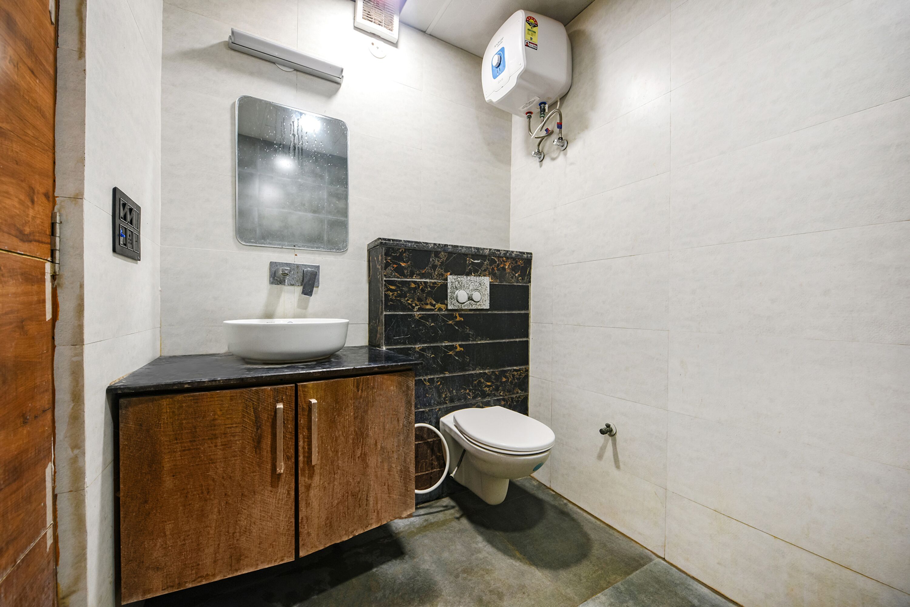 A bathroom with a marble sink, a toilet, and a shower.