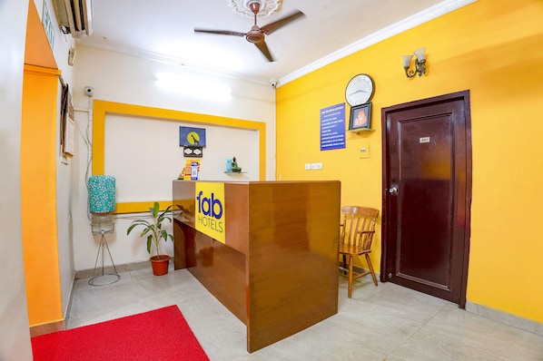 A reception desk with a sign for 'fab hotels', a clock, a door labeled '501', and a ceiling fan. - Fabhotel Home Tree Service Apartment T Nagar (Chennai)
