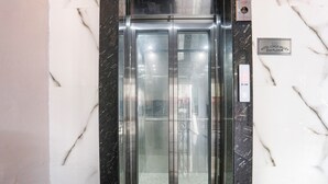 Ein Aufzug mit digitaler Anzeige, einem Schild für die 2. Etage und Marmorwänden.