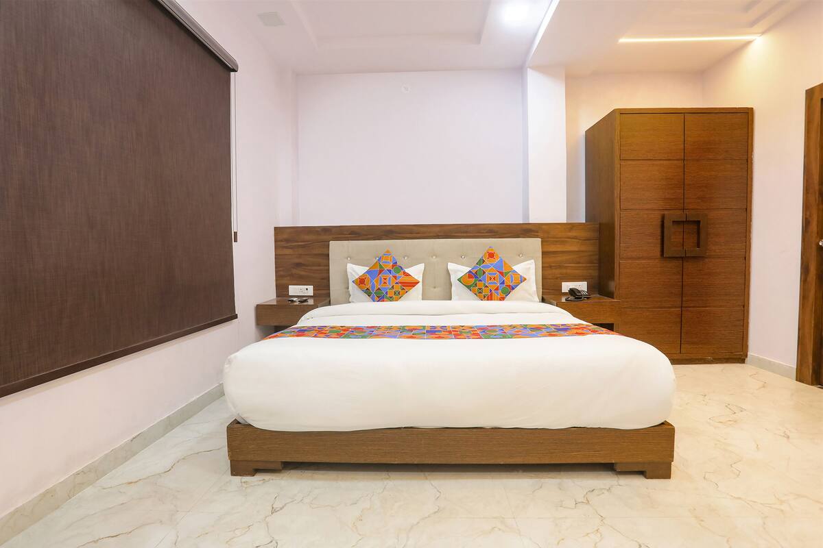 A bedroom with a large bed, a wardrobe, and a nightstand.
