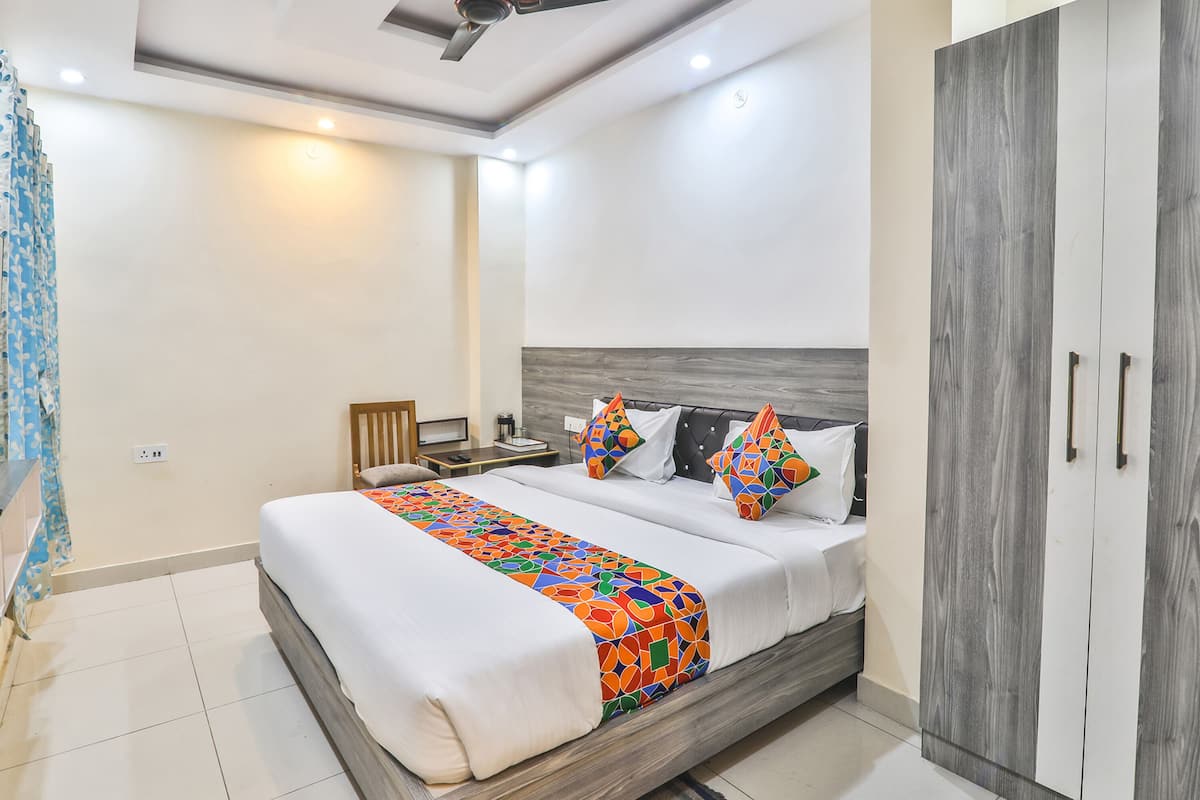 A bedroom with a bed, nightstand, wardrobe, and a ceiling fan.