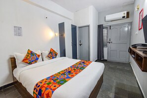 Cozy retreat with a neatly made bed, wooden headboard, and a bedside table with a lamp.