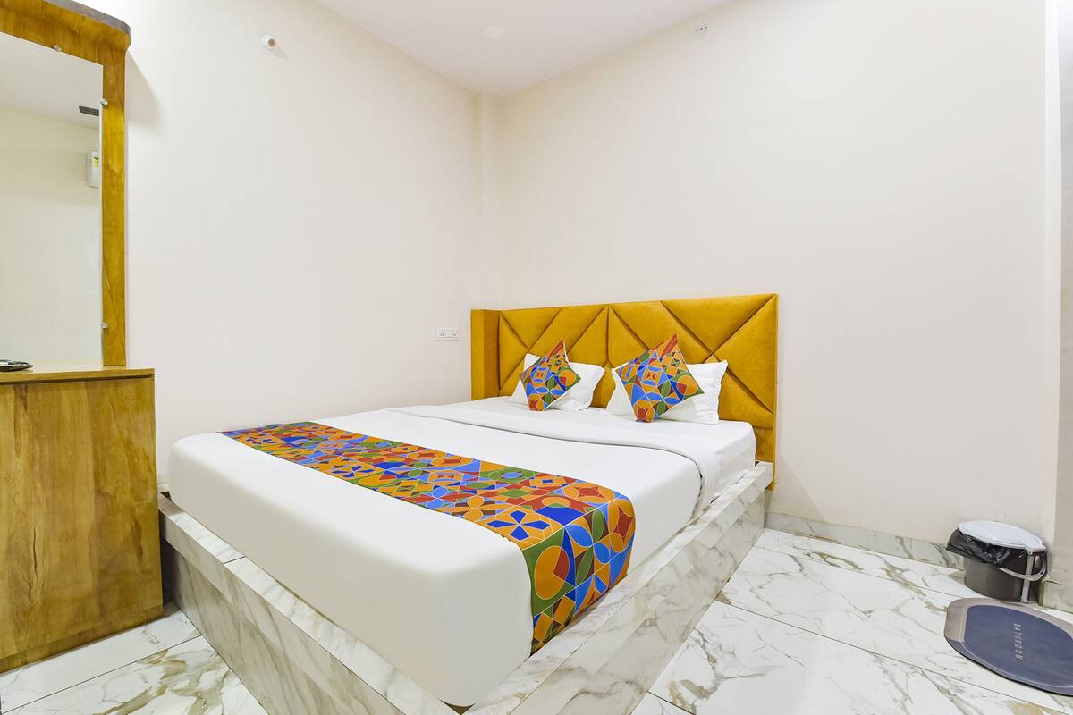 Ein Hotelzimmer mit einem Bett, einem Holzschrank, einem Marmorboden und einer Körperwaage.