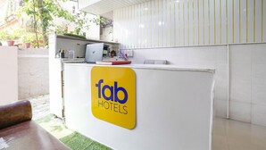 A reception desk with a 'fab hotels' sign, a computer, and a small plant. - Fabhotel Abhisiddhi Residency (Navi Mumbai)