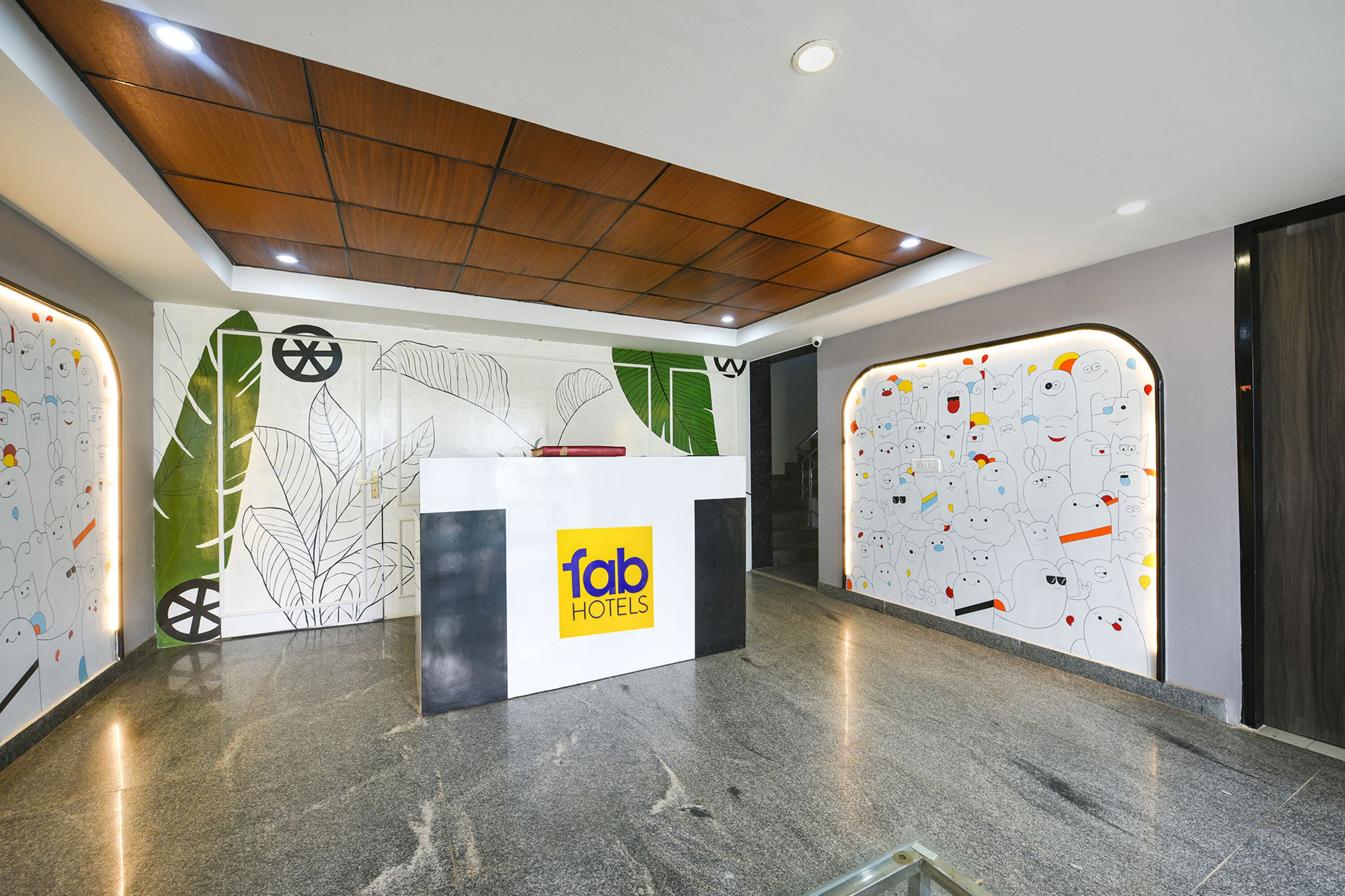 A reception desk with a logo, a wooden ceiling, and a wall with a leaf pattern.