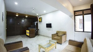 A hotel lobby with a reception desk, a sofa, a coffee table, and a television on the wall. - Fabhotel Comfort Stays (Panaji)