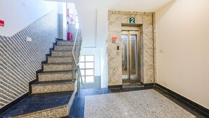 A hotel lobby with a marble staircase, an elevator, and a carpeted floor. - Fabhotel Shree Jii Luxury (New Delhi)