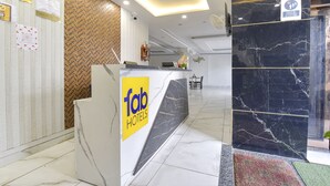 A hotel reception area with a marble counter, a chandelier, and a sign for 'Tab Hotels'. - Fabhotel Dev Palace (Haridwar)
