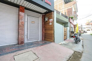 Un commerce fermé, avec une pancarte indiquant « réception », une moto garée devant, et un immeuble d’habitation en arrière-plan.