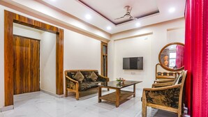 Una sala de estar moderna con una puerta de madera, un sofá, una mesa de centro y un televisor.