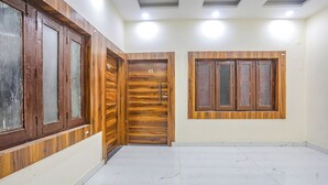 Una habitación con puerta de madera, ventana y suelo de baldosas.