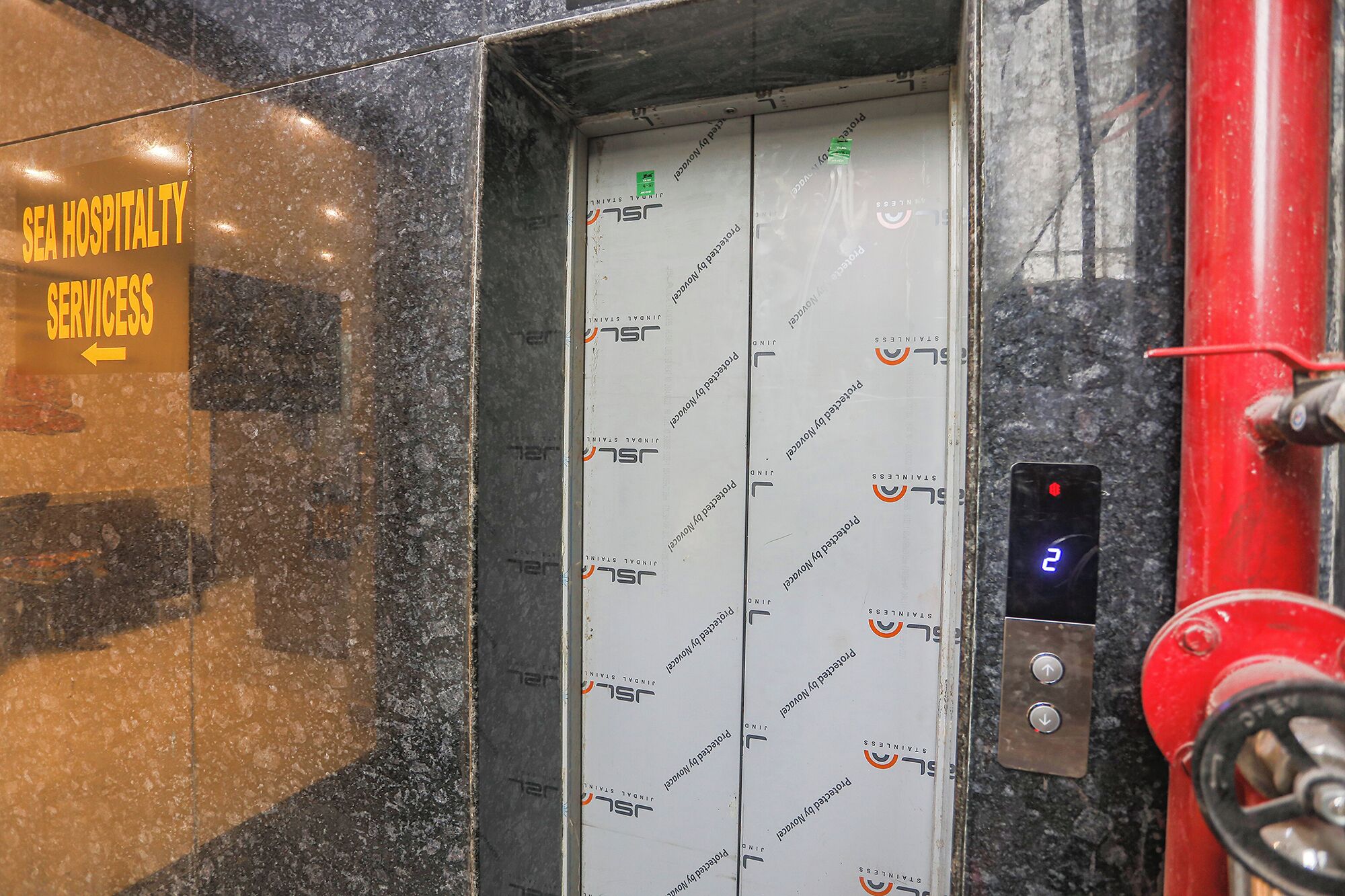 An elevator with a sign indicating 'SEA HOSPITALITY SERVICES' and a directional arrow.