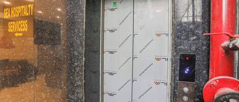 An elevator with a sign indicating 'SEA HOSPITALITY SERVICES' and a directional arrow.