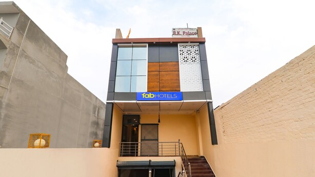 Un hôtel moderne dont la façade porte une enseigne indiquant « R.K. Palace » et « fabHOTELS ».