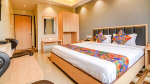 Quarto de hotel moderno com uma cama grande, uma escrivaninha e uma cadeira.
