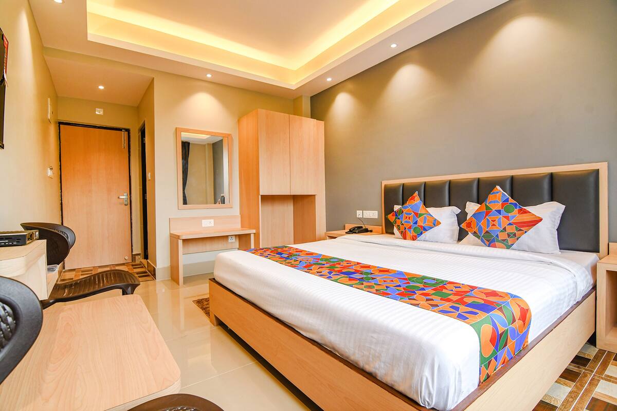 Una habitación de hotel moderna con una cama grande, un escritorio y una silla.