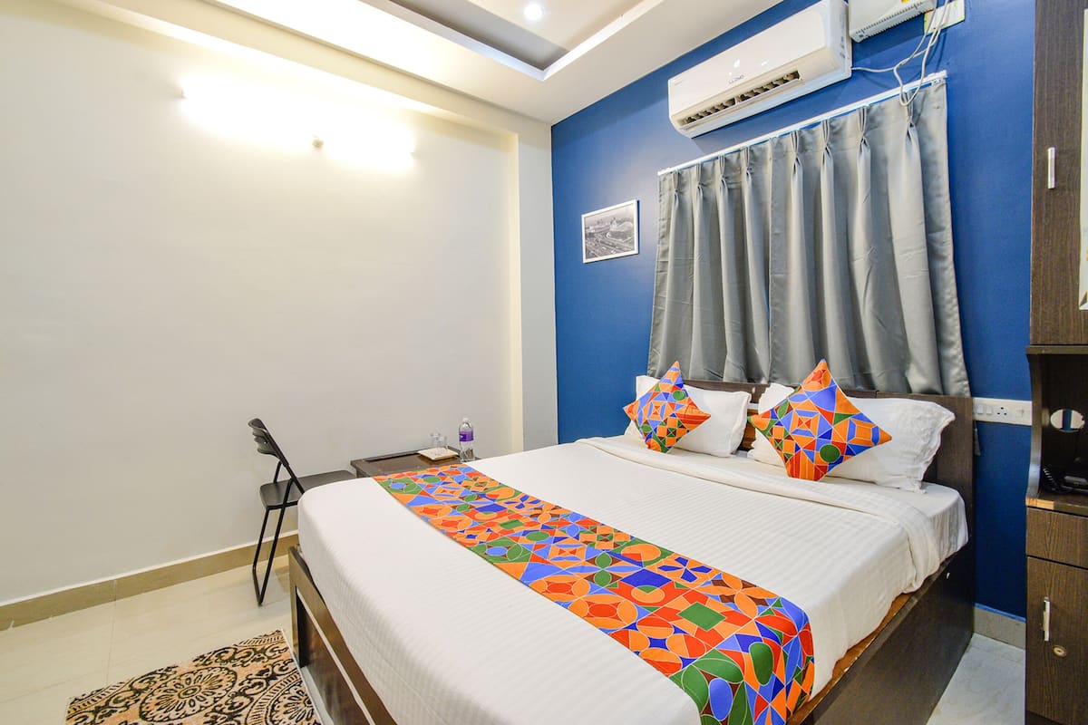 A bedroom with a bed, a desk, and a chair.