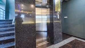 Een lift in een gebouw, met een bordje dat aangeeft dat het een openbare ruimte is.