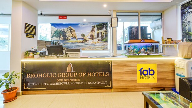 Een receptiebalie met een bord voor Broholic Group of Hotels, met vestigingen in Hi-Tech City, Gachibowli, Kondapur en Kukatpally.