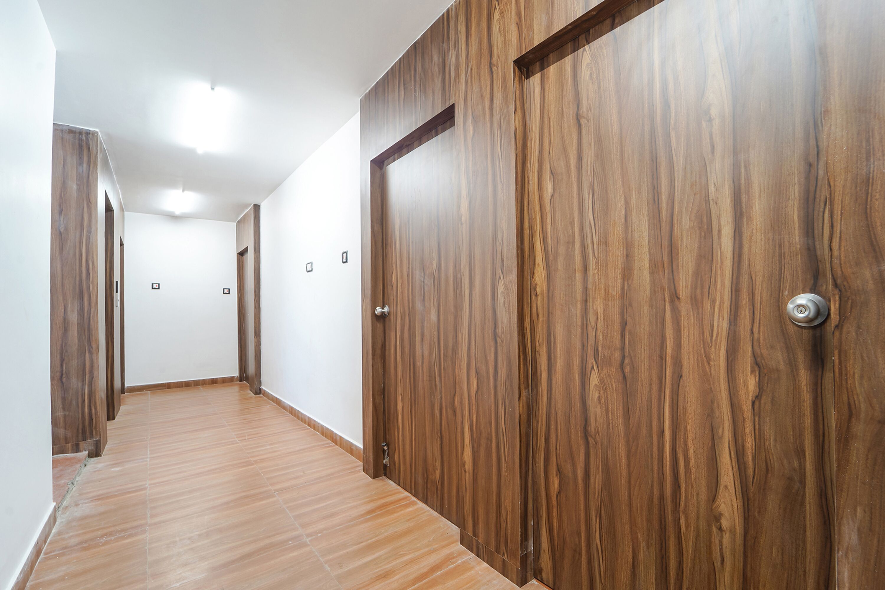 A hallway with wooden doors and a tiled floor.