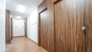 A hallway with wooden doors and a tiled floor. - Fabhotel Chakra (Coimbatore)