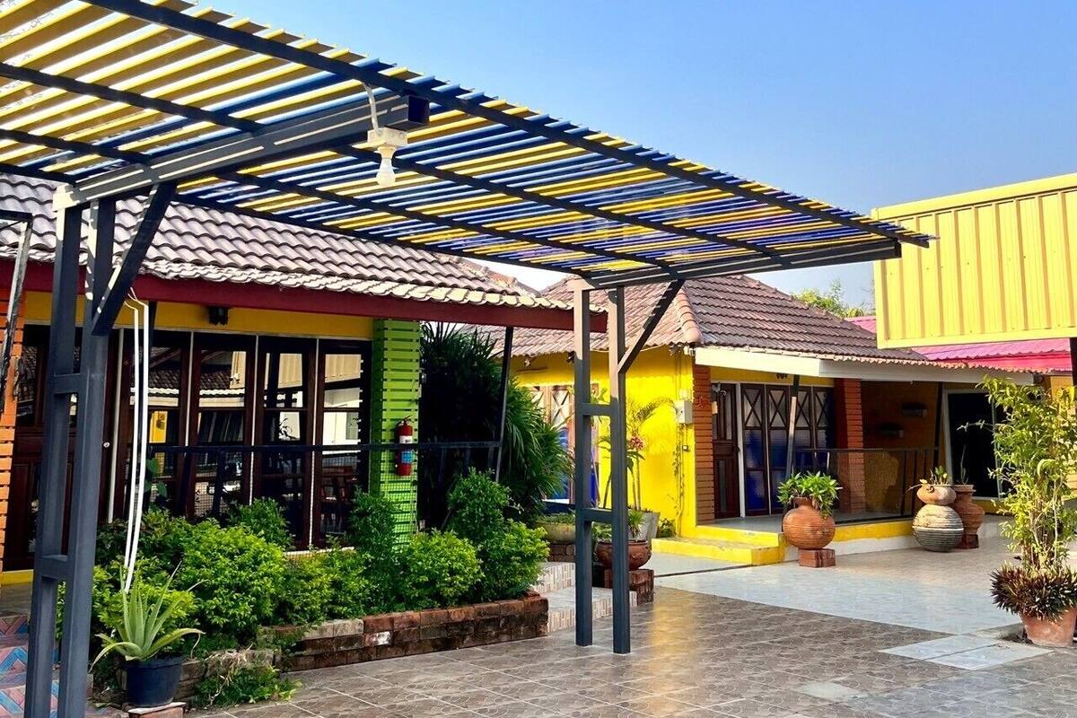 A covered outdoor area with a tiled floor, a pergola, and potted plants.
