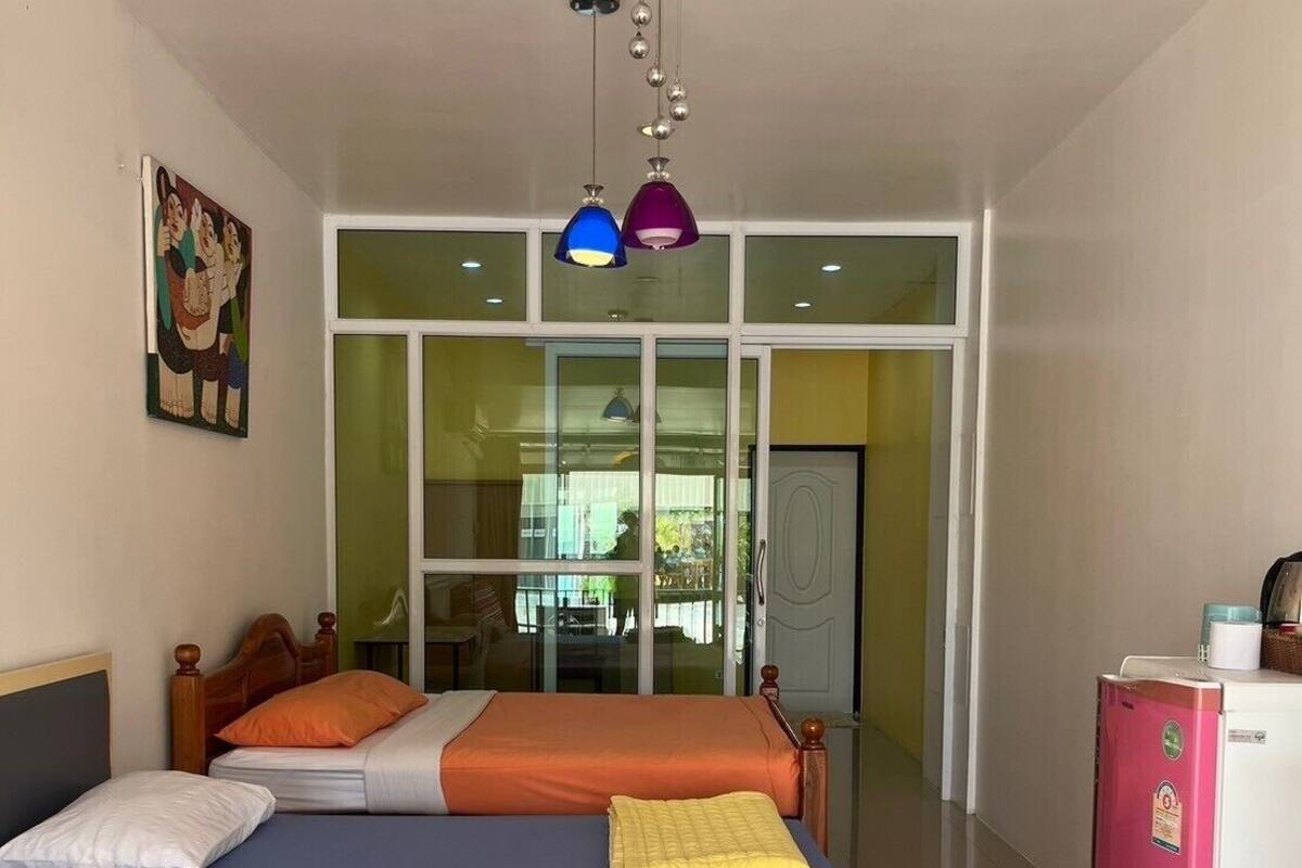 A hotel room with a bed, a refrigerator, and a window.