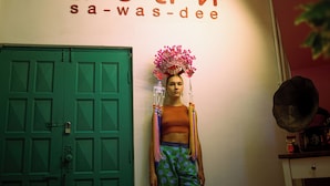 A wall with the text "sa-was-dee" and a green door.