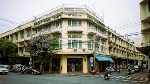 A multi-story building with balconies and a ground-level shop.
