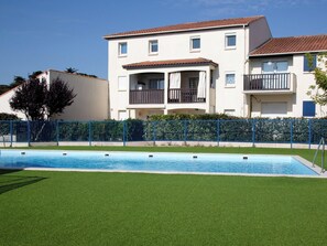 A two-story building with a swimming pool in front.