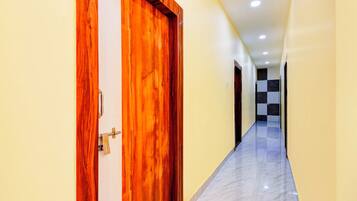 A hallway with a wooden door and a checkered floor.