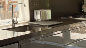 Una cocina moderna con electrodomésticos de acero inoxidable, lavavajillas integrado y ventana con vistas al paisaje.
