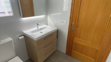 Een haardroger, handdoeken, zeep, toiletpapier