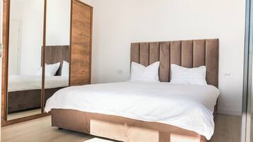 Ein Schlafzimmer mit einem großen Bett, einem Holz-Kopfteil und einem Spiegel an einer Wand.