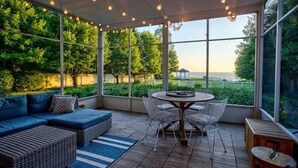 A covered outdoor area with a sofa, chairs, and a table.