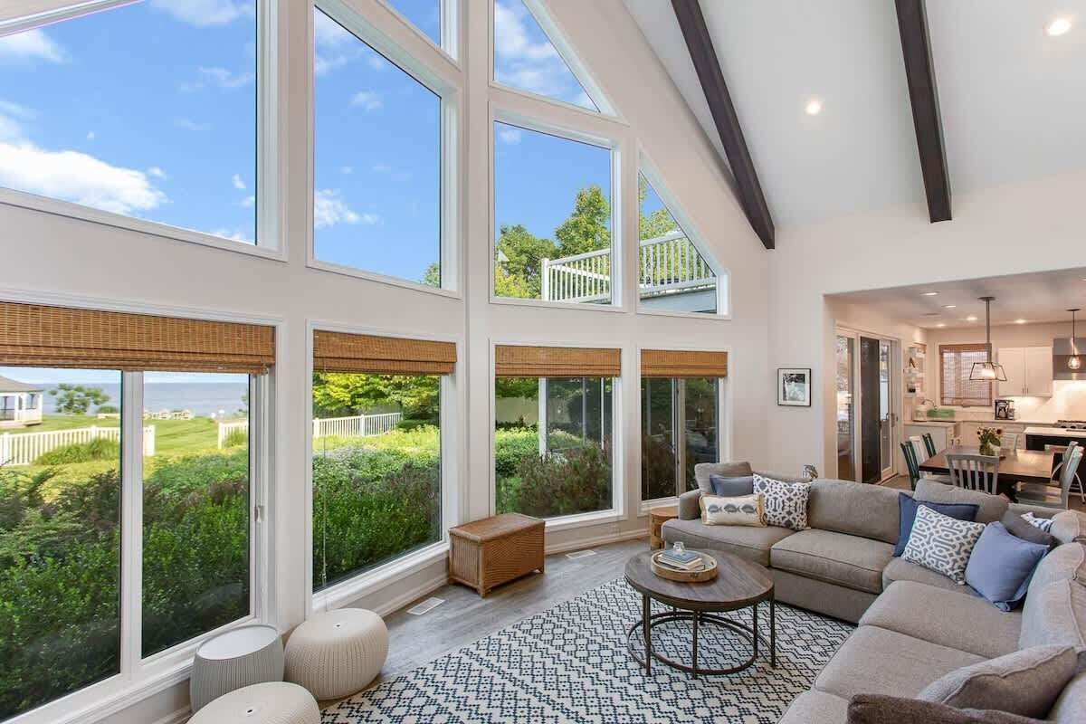 A spacious living room with large windows, a cozy seating area, and a view of the outdoors.