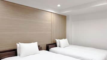 A hotel room with two beds, wooden headboards, and recessed ceiling lighting.