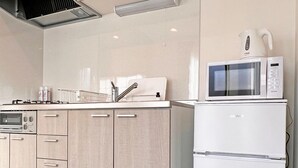 Une cuisine moderne équipée d’un four à micro-ondes encastré, d’une bouilloire et d’une cuisinière.