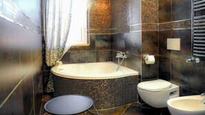 A modern bathroom with a freestanding bathtub, a toilet, and a sink. - Airport bari deluxe  (Bari)