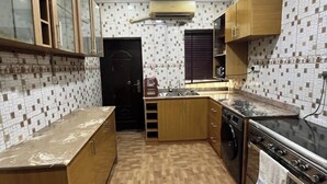 Una cocina compacta con armarios de madera, horno integrado y salpicadero de azulejos.