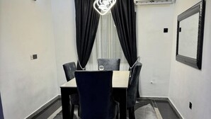 Un comedor con una mesa, sillas y una lámpara de araña.