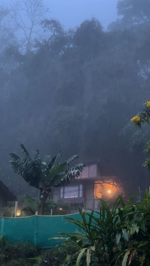 Una casa con una ventana visible y una luz encendida en su interior.