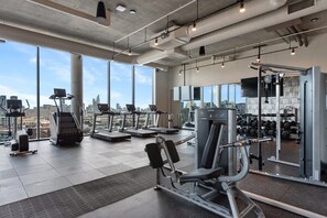 A spacious gym with treadmills, weight machines, and a large mirror.