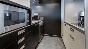 A modern kitchen with a built-in microwave, coffee maker, and toaster. - Bright apartment, ski-in/ski-out, WIFI (Tignes)