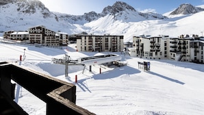 A snow-covered ski resort with multiple buildings, including a TIFES hotel, and a ski lift in the foreground. - Bright apartment, ski-in/ski-out, WIFI (Tignes)