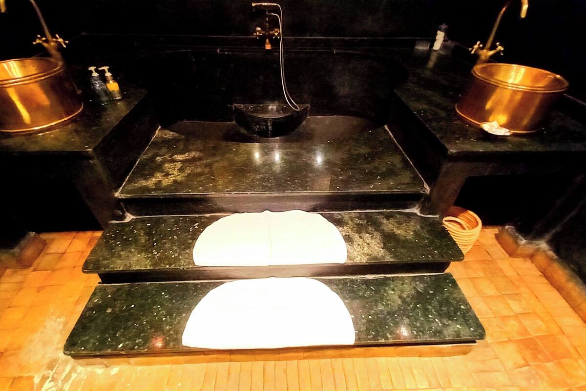 A kitchen with a stove, two sinks, and a wooden floor.